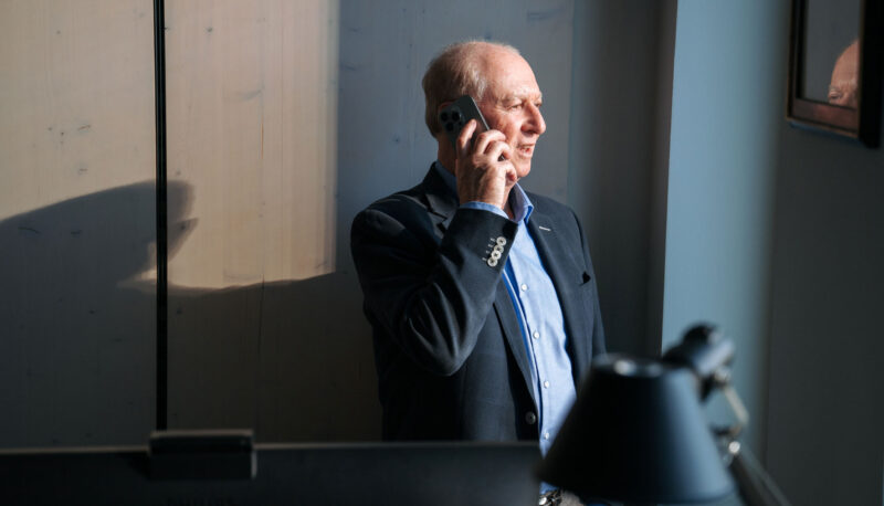 beka Teammitglied telefoniert mit Smartphone am Fenster