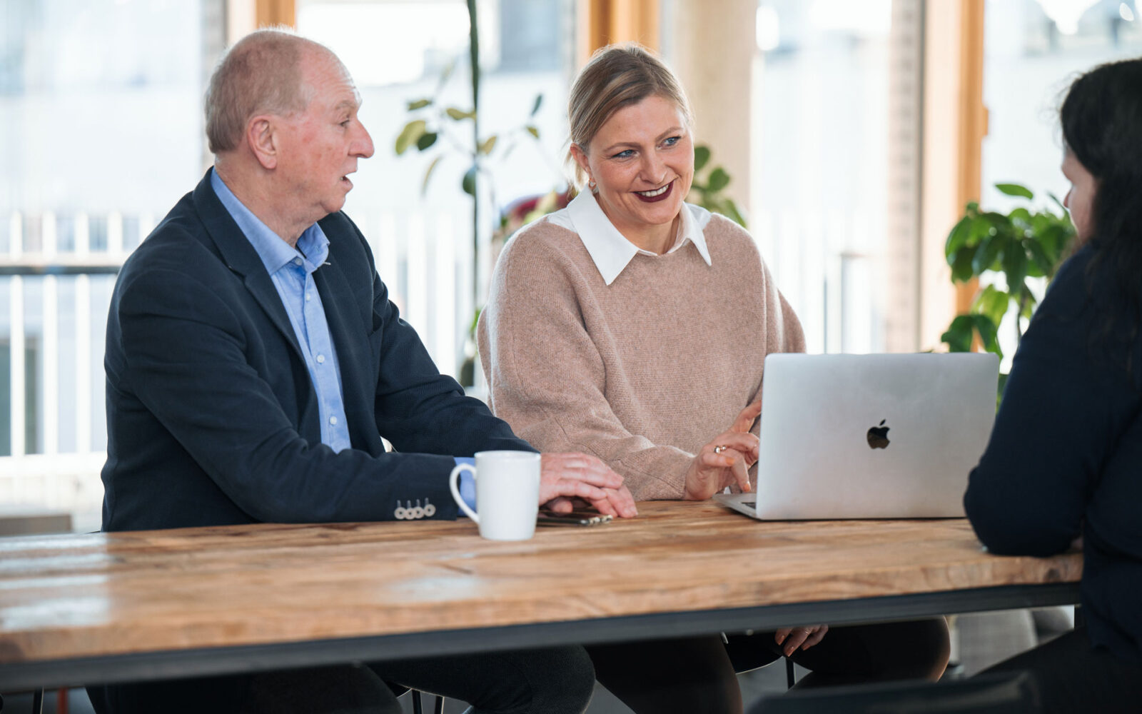 Seminar Teilnehmende sitzen an Tisch mit Laptop