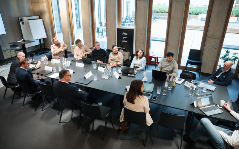 Seminar-Teilnehmende an großem Tisch in Meeting